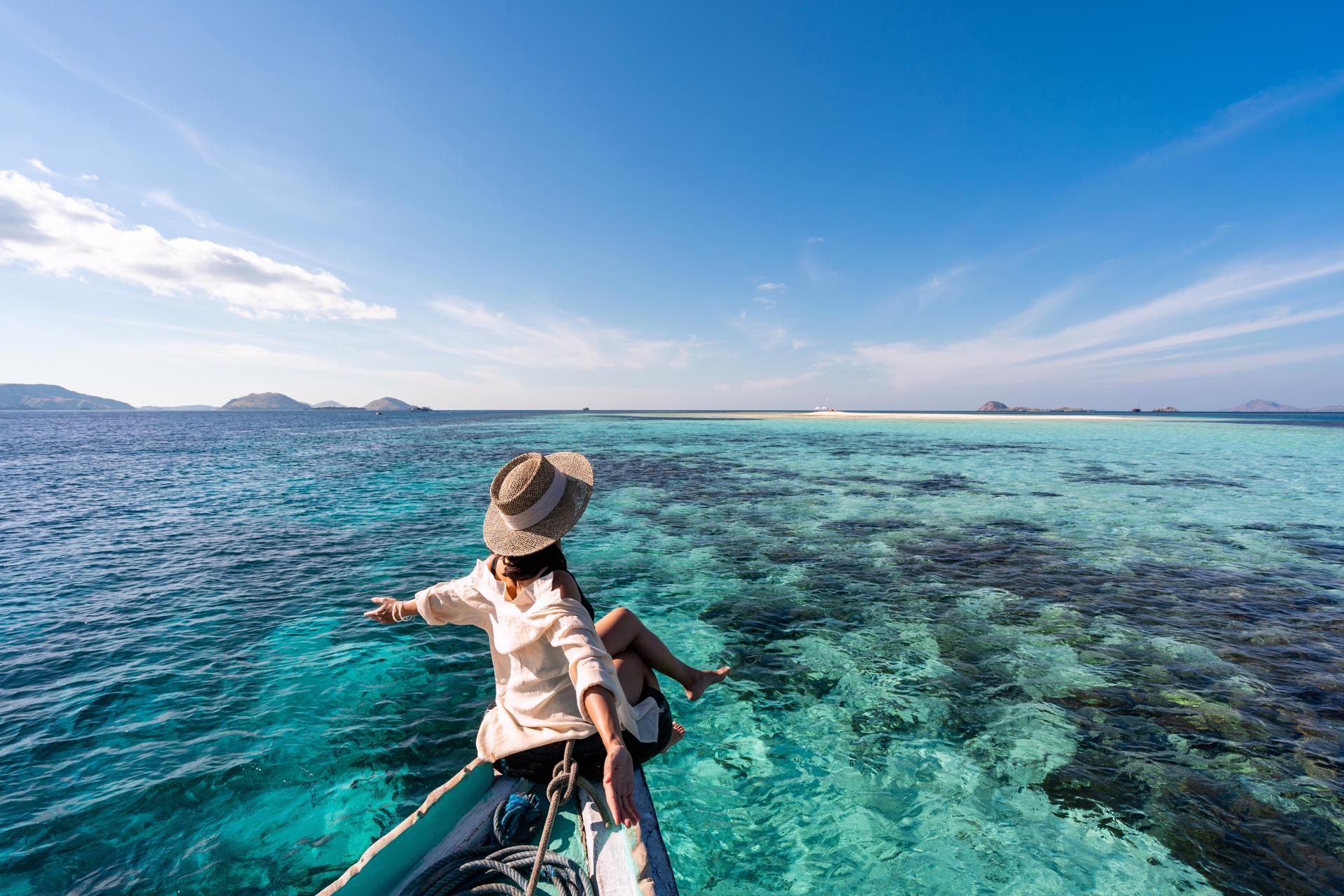 Young woman traveler relaxing and enjoying the tropical sea while traveling for summer vacation, Travel lifestyle concept